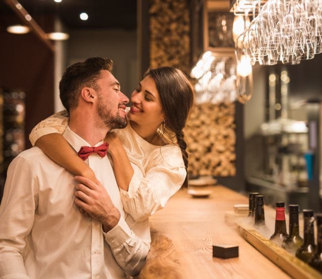 happy-woman-hugging-cheerful-man-bar-counter (1)